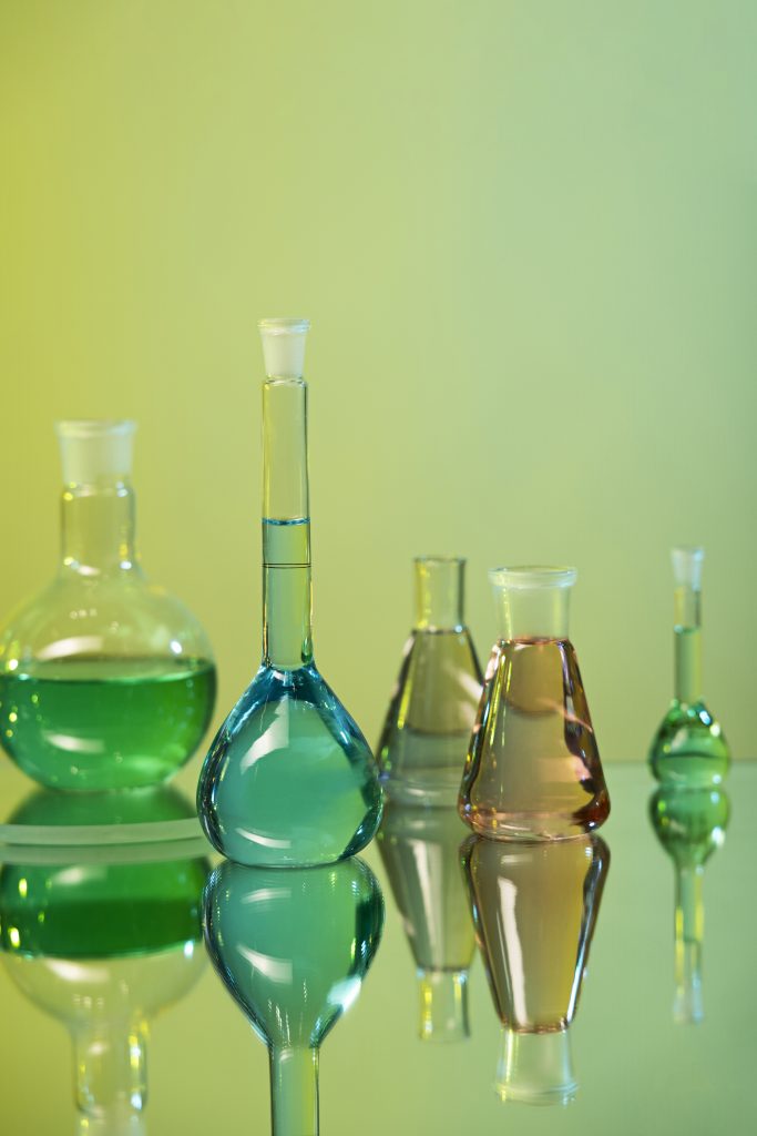 laboratory glassware assortment with green background scaled