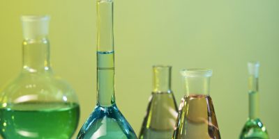laboratory glassware assortment with green background scaled